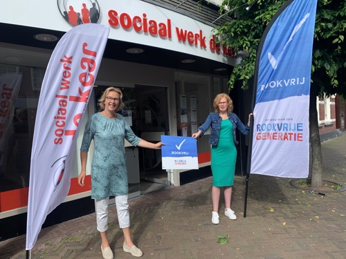 Op de foto overhandigt wethouder Luciënne Boelsma van gemeente De Fryske Marren (links) het bord 'Rookvrij' aan Henrike Hofsteenge, directeur Sociaal Werk De Kear.