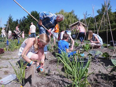 Afbeelding van kinderen die in een moestuin tuinieren